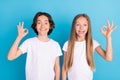 Photo portrait boy girl smiling showing okay sign each other isolated pastel blue color background Royalty Free Stock Photo