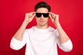 Photo portrait brunet guy in casual outfit serious wearing sunglass isolated vibrant red color background