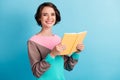 Photo portrait of cheerful happy female student holding yellow book smiling isolated on bright blue color background Royalty Free Stock Photo