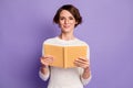 Photo portrait of clever female student smiling with book wearing eyewear isolated on vibrant purple color background
