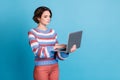 Photo portrait of concentrated serious female freelancer using keeping laptop browsing internet isolated on bright blue Royalty Free Stock Photo