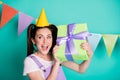 Photo portrait of curious birthday girl with tails trying to guess what& x27;s inside present smiling isolated on vivid teal Royalty Free Stock Photo