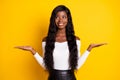 Photo portrait of curious girl keeping copyspaces on hand scaling comparing smiling isolated vibrant yellow color