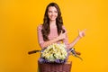 Photo portrait of curious girl pointing fingers on copyspace on bicycle with basket of flowers isolated on vibrant Royalty Free Stock Photo