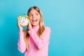 Photo portrait of curious girl showing colorful clock listening looking at blank space isolated on bright turquoise