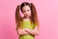 Photo portrait of cute little girl crossed hands moody irritated dressed stylish green clothes on pink color