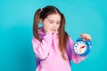 Photo portrait of cute little girl look sad alarm clock dressed stylish pink clothes isolated on aquamarine color Royalty Free Stock Photo