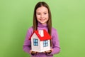 Photo portrait of cute small kid schoolgirl holding apartment please adopt her orphan new house family isolated on green Royalty Free Stock Photo