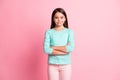 Photo portrait of cute sweet little hispanic girl smiling with crossed hands  on pink color background Royalty Free Stock Photo