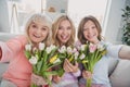 Photo portrait of different generations women spending 8 march together happy laughing with tulips taking selfie at home Royalty Free Stock Photo