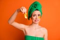 Photo portrait of disgusted girl holding one golden eye patch with fingers isolated on vivid orange colored background