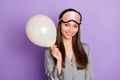 Photo portrait of dreamy woman in pajama keeping white air balloon on pastel violet color background