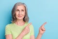 Photo portrait elder woman curious interested smiling pointing blank space isolated pastel blue color background Royalty Free Stock Photo
