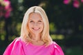 Photo portrait elder woman smiling in pink dresswalking in green park on summer streets happy overjoyed