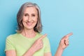 Photo portrait elder woman smiling showing finger blank space isolated pastel blue color background Royalty Free Stock Photo