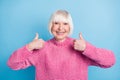 Photo portrait of elderly woman showing two thumbs up isolated on pastel blue colored background Royalty Free Stock Photo