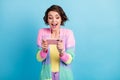 Photo portrait of excited girl playing video games on phone holding in two hands horizontally  on pastel blue Royalty Free Stock Photo