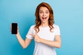 Photo portrait of excited girl pointing finger at phone with blank display space isolated on pastel blue colored Royalty Free Stock Photo