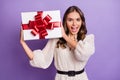 Photo portrait of excited model trying to guess what inside present box with ribbon isolated on pastel purple color Royalty Free Stock Photo