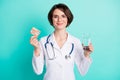 Photo portrait of female doctor keeping medicine pills water glass isolated bright turquoise color background Royalty Free Stock Photo