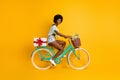 Photo portrait full body side view of bicycle rider delivering big white present isolated on vivid yellow colored Royalty Free Stock Photo