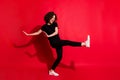 Photo portrait full body view of girl kicking raising leg dancing isolated on vivid red colored background Royalty Free Stock Photo