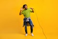 Photo portrait full body view of man holding microphone singing isolated on vivid yellow colored background Royalty Free Stock Photo