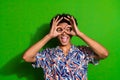 Photo portrait of funny joking happy student man comic showing okey sign his eyes looks like goggles isolated over green