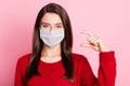 Photo portrait of funny pretty girl showing small size measures with fingers wearing white face mask isolated on pink Royalty Free Stock Photo