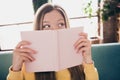 Photo portrait of funny young teenage blonde hair girl in yellow sweater holding open book curious seeing her plans at Royalty Free Stock Photo