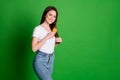 Photo portrait of girl brushing hair isolated on vivid green colored background with blank space