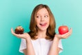 Photo portrait girl comparing sweet cupcake apple licking lip hungry isolated bright teal color background Royalty Free Stock Photo