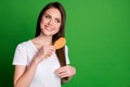 Photo portrait of girl grooming hair with brush isolated on vivid green colored background