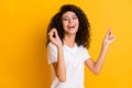 Photo portrait of girl laughing dancing clicking fingers overjoyed isolated on vibrant yellow color background