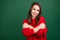 Photo portrait girl in red pullover embracing herself smiling isolated green color background copyspace Royalty Free Stock Photo