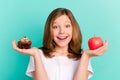 Photo portrait girl scaling sweet cupcake apple smiling happy isolated bright teal color background Royalty Free Stock Photo