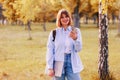 Photo portrait of girl student holding phone and laptop and smiling outdoors in the park Royalty Free Stock Photo