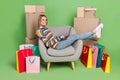 Photo portrait girl using laptop sitting in grey chair near packages online shopping isolated pastel green color Royalty Free Stock Photo