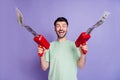 Photo portrait of handsome young man holding money gun cheerful crazy dressed stylish gray clothes isolated on purple