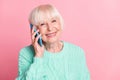 Photo portrait of happy grandmother smiling talking on mobile phone communicating isolated on pastel pink color Royalty Free Stock Photo