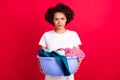 Photo portrait housewife angry keeping bowl of dirty clothes need wash isolated vivid red color background