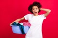 Photo portrait housewife shocked bad mood keeping bowl of dirty clothes need wash isolated vibrant red color background