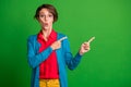 Photo portrait of impressed surprised brunette female student showing blank space in spectacles isolated on vivid green