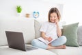 Photo portrait little girl sitting on couch talking writing notes in diary talking on cellphone Royalty Free Stock Photo