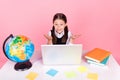 Photo portrait little girl sitting at desk using laptop remote education not know answer isolated pastel pink color