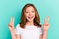 Photo portrait little girl smiling showing v-sign gesture isolated vibrant teal color background Royalty Free Stock Photo