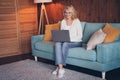 Photo portrait of lovely retired woman sit sofa work remotely dressed casual outfit cozy home interior living room in Royalty Free Stock Photo