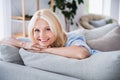 Photo portrait of lovely senior lady sit sofa charming smile new apartment renting house interior design cozy living Royalty Free Stock Photo