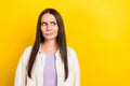 Photo portrait of lovely young lady look skeptical thoughtful empty space wear trendy white outfit isolated on yellow