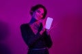Photo portrait of lovely young lady look white screen eshopping wear trendy overall garment isolated on neon light pink